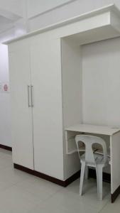 a white desk and a chair in a room at Sharana Pensionne in Davao City