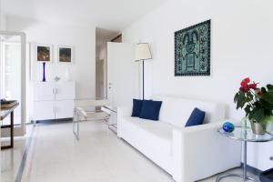 a white living room with a white couch and a table at Holiday home Fiorita in Portovenere