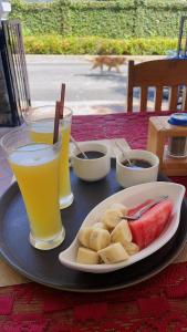 einen Tisch mit einem Teller Essen und zwei Getränken in der Unterkunft PhaiLin Hotel in Luang Prabang