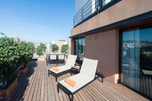 - un balcon avec 2 chaises blanches dans un bâtiment dans l'établissement Europark, à Barcelone
