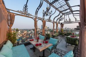 ein Restaurant mit einem Tisch und Stühlen auf einem Balkon in der Unterkunft Hanoi Tirant Hotel in Hanoi
