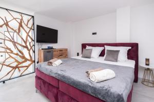 ein Schlafzimmer mit einem großen Bett mit zwei Handtüchern darauf in der Unterkunft Astonishing villa Blue Horizon w heated pool in Podstrana + 55 Fotos