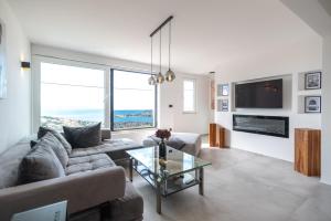 ein Wohnzimmer mit einer Couch und einem Glastisch in der Unterkunft Astonishing villa Blue Horizon w heated pool in Podstrana