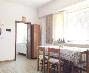 ein Esszimmer mit einem Tisch und einem Fenster in der Unterkunft Appartamento ALICE a Marina di Cecina in Marina di Cecina