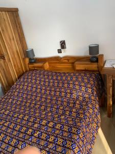 - une chambre avec un lit et une couette bleue dans l'établissement pavillon « lilas » à dagué-togo, à Dagé