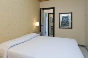 a bedroom with a white bed and a mirror at Holiday home Fiorita in Portovenere