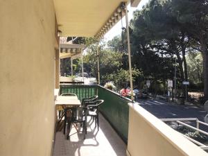 eine Außenterrasse mit Tischen und Stühlen auf dem Balkon in der Unterkunft Appartamento ALICE a Marina di Cecina in Marina di Cecina