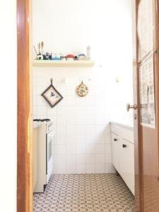 eine kleine Küche mit weißem Fliesenboden in der Unterkunft Appartamento ALICE a Marina di Cecina in Marina di Cecina