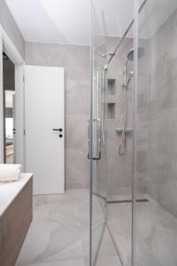 eine Dusche mit Glastür im Badezimmer in der Unterkunft Astonishing villa Blue Horizon w heated pool in Podstrana