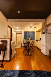 cocina y sala de estar con mesa y nevera en おやど紀伊国屋諏訪町, en Asahimachi