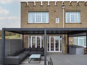 a patio with a couch and a table in front of a building at Castle Top Haven in Market Rasen