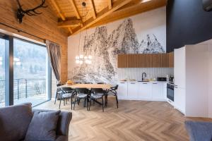 a kitchen and dining room with a table and chairs at CASA IL TRAMONTO Val di Sole in Commezzadura