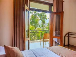 a bedroom with a bed and a view of a balcony at Ella, Nine Glow Resort in Ella