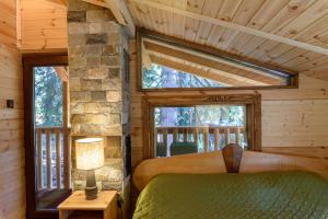 a bedroom in a log cabin with a bed and a window at Life House-Semkovo in Semkovo