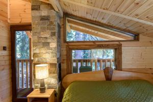 1 dormitorio en una cabaña de madera con cama y ventana en Life House-Semkovo, en Belitsa