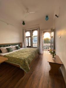 a bedroom with a large bed with a green bedspread at Devi Villa in Udaipur