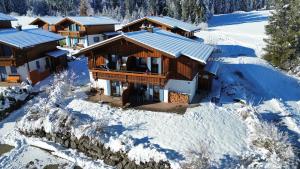 una vista aérea de una casa en la nieve en Feriendorf Via Claudia Haus 99 Julia, en Lechbruck