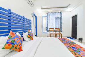 - une chambre avec un grand lit blanc et des oreillers colorés dans l'établissement FabHotel Istana Inn, à Jaipur