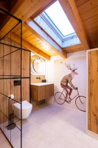 baño con un mural de un ciervo montado en bicicleta en CASA IL TRAMONTO Val di Sole en Commezzadura