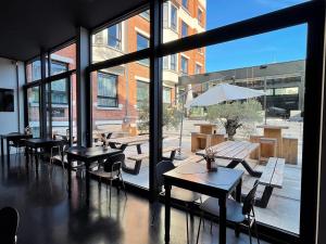 a restaurant with tables and chairs and a large window at Hotel Elisabeth in Mechelen