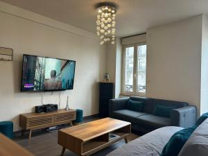 - un salon avec un canapé et une télévision murale dans l'établissement Résidence Investar appartement 3, à Montluçon