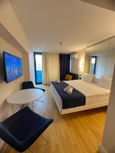 巴統的住宿－Batumi Orbi City，酒店客房设有一张大床和一张桌子。