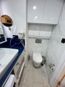 a bathroom with a white toilet and a sink at Batumi Orbi City in Batumi