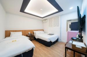 a hotel room with two beds and a tv at Must Stay Mokdong in Seoul