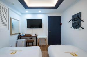 Zimmer mit einer schwarzen Tür und einem TV an der Wand in der Unterkunft Must Stay Mokdong in Seoul