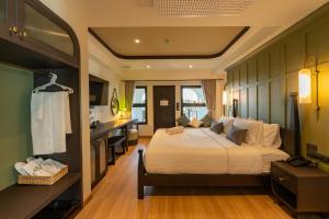 a bedroom with a large bed and a kitchen at Shamrock Chiangmai Hotel in Chiang Mai