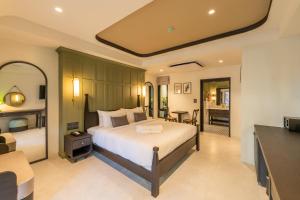 a bedroom with a bed and a living room at Shamrock Chiangmai Hotel in Chiang Mai