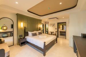チェンマイにあるShamrock Chiangmai Hotel-Adult Onlyのベッドとリビングルームのある寝室