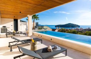 a villa with a swimming pool and a view of the ocean at Majestic Villa Lidija by Irundo in Dubrovnik