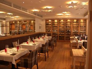 un restaurante con mesas y sillas blancas y un bar en Alpin Lifestyle Hotel Löwen & Strauss en Oberstdorf