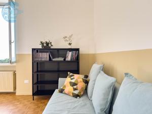 ein Schlafzimmer mit einem Bett mit Kissen und einem Bücherregal in der Unterkunft Viale Miramare 157 Tirabora Short Rent in Triest