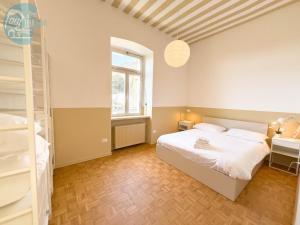 トリエステにあるViale Miramare 157 Tirabora Short Rentのベッドルーム(白いベッド1台、窓付)