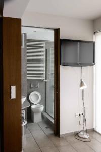 a bathroom with a toilet and a glass door at Bright Loft With Terrance - Next to Metro Kerameikos in Athens