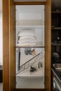 a closet filled with white towels in a kitchen at Bright Loft With Terrance - Next to Metro Kerameikos in Athens