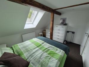 Un dormitorio con una cama verde y blanca y una ventana en gemütliche Ferienwohnung in Seenähe, en Neustrelitz