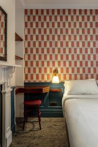 ein Schlafzimmer mit einem Bett und einem Schreibtisch mit einer Lampe in der Unterkunft St. David's Hotels Paddington in London