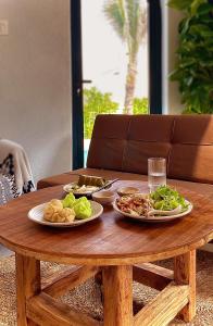 una mesa de madera con dos platos de comida. en Lo Villa Phu Yen, en Phú Hiệp