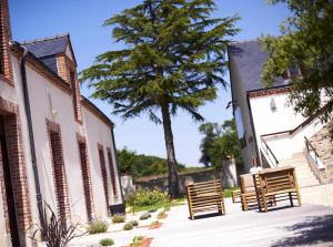 a group of chairs sitting next to a building at Logis Hôtel La ferme du Blanchot in Crossac