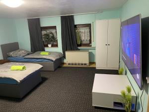 Habitación con 2 camas y TV de pantalla plana. en Chambre avec 3 lits en Tréveris