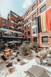 un patio avec des chaises et des parasols en face d'un bâtiment dans l'établissement Hotel Elisabeth, à Malines