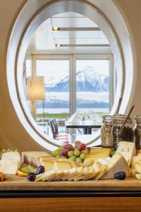 a table with a bunch of cheese and other foods at Neuhaus Golf- & Strandhotel in Interlaken