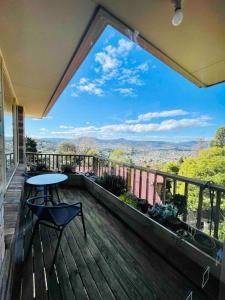 a balcony with a table and a view of the mountains at Cosy Guesthouse with River Views in Lenah Valley