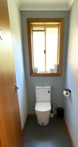 a bathroom with a toilet and a window at Cosy Guesthouse with River Views in Lenah Valley