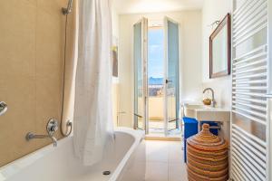 a bathroom with a tub and a sink at RivieraRent La Terrazza sul mare in Pietra Ligure