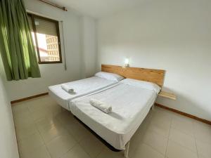 Łóżko lub łóżka w pokoju w obiekcie Apartamentos Bernat 3000