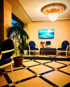 een lobby met stoelen en een tv aan de muur bij Deluxe Newport Hotel in Istanbul